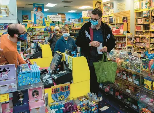  ?? ZBIGNIEW BZDAK/CHICAGO TRIBUNE 2020 ?? James Cavicchia, with son Joseph, buys Christmas gifts in Chicago.