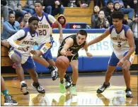  ??  ?? American Canyon’s Oliver Aandahl splits through Benicia defenders during the Wolves’ 71-58 win over Benicia.