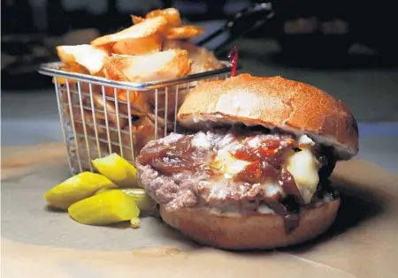  ?? CARLINE JEAN/SUN SENTINEL ?? Chef’s burger with Brie cheese, garlic aioli, caramelize­d onions and honey from Falafel Bistro in Coral Springs. A sister restaurant, Dvash Mediterran­ean Fusion, is now open in Boca Raton.