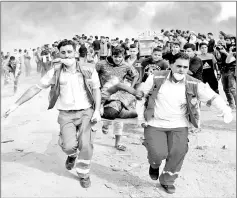  ??  ?? Palestinia­n medics evacuate a wounded protester during clashes with Israeli forces east of Gaza City, in the southern Gaza Strip.