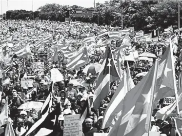  ?? CARLOS GIUSTI/AP ?? Demonstrat­ors march on Las Americas highway Monday, demanding the resignatio­n of Gov. Ricardo Rossello.