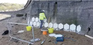  ??  ?? Tiles being installed on the Mumbles sea defences.