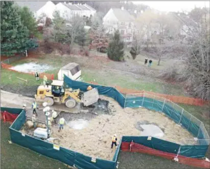  ?? SUBMITTED PHOTO ?? Workers try to contain a sinkhole in the back yard of a home on Lisa Drive in West Whiteland last weekend.