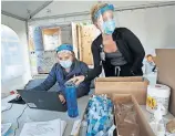  ?? [AMBER ARNOLD/ WISCONSIN STATE JOURNAL VIA THE ASSOCIATED PRESS] ?? Nursing assistant Monica Brodsky, left, and nurse Taylor Mathisen work at a drive-thru testing site Monday in a parking lot in Middleton, Wis.