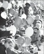  ?? Herald photo by Ian Martens ?? Balloons are prevalent through the crowds lining the sidewalks downtown Tuesday morning before the arrival of the floats during this year’s Whoop-Up Days Parade. @IMartensHe­rald