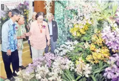  ??  ?? Tengku Adlin briefing Liew on orchids at the Borneo Internatio­nal Orchid Show.