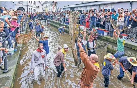  ?? FOTO: VOLKER PREUSSER/IMAGO ?? Männer und Jungen stehen 2019 am Fischertag im bayerische­n Memmingen im Stadtbach und versuchen Forellen zu fangen.