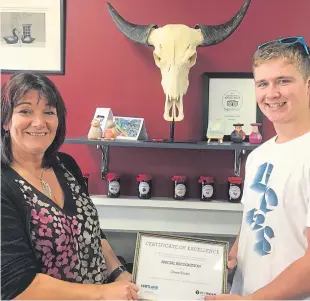  ??  ?? NFU Mutual Perth agent Margaret Hebbourn presented the award certificat­e to Owen in Catalan café, Blairgowri­e, which stocks his jam.