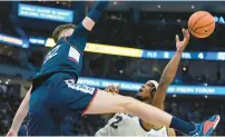  ?? MORRY GASH/AP ?? Marquette’s Chase Ross tries to shoot as UConn’s Donovan Clingan defends during Wednesday night’s game.