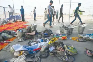  ?? AFP PHOTO ?? SADDENING SIGHT
Men walk across the site of a deadly stampede near the town of Hathras, Uttar Pradesh state, northern India, on July 3, 2024.