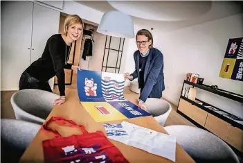  ??  ?? Vera und Philippe Henco zeigen einige Motive, die sie für die „Tokyodorf“-Kampagne entwickelt haben wie etwa die Winkekatze und ein Alt.