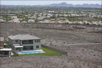  ?? AP file photo ?? A home with a swimming pool abuts the desert on the edge of the Las Vegas valley July 20, in Henderson, Nev. Nevada lawmakers on Monday considered another shift in water use for one of the driest major metropolit­an areas in the U.S. The water agency that manages the Colorado River supply for Vegas sought authority to limit what comes out of residents’ taps.