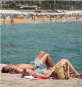  ?? EMILIO MORENATTI/AP FILE ?? People sunbathe on a beach in Barcelona, Spain, last week. A heat wave that’s lasted more than a week keeps on baking the U.S., Asia, Europe and even the Arctic.