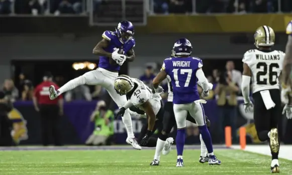  ?? HANNAH FOSLIEN/GETTY IMAGES ?? Minnesota’s Stefon Diggs comes down with Case Keenum’s desperatio­n pass, then spins away from the New Orleans defence to race for a game-winning touchdown as time runs out in their NFC playoff game. The Vikings, who blew a 17-point lead, won 29-24 and...