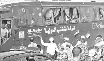  ?? — AFP photo ?? Busses transporti­ng residents and fighters from the towns of Fuaa and Kefraya arrive in the Syrian regime-held territory of the al-Eis crossing point south of Aleppo.