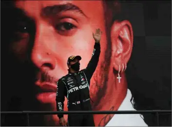  ?? Jose Sena Goulao, Pool via AP ?? Mercedes driver Lewis Hamilton of Britain waves from the podium after his record-breaking win during the Formula One Portuguese Grand Prix at the Algarve Internatio­nal Circuit in Portimao, Portugal, on Sunday.