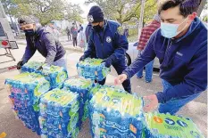  ?? DAVID J. PHILLIP/ASSOCIATED PRESS ?? Donated bottles of water are distribute­d to residents in Houston as the state’s largest city and surroundin­g areas are under a boil water notice as many Texans are still without safe drinking water in their homes.