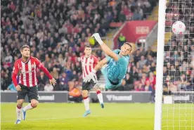  ?? Photo / AP ?? Southampto­n keeper Alex Mccarthy’s despairing dive couldn’t prevent a fluky goal from Liverpool’s Joel Matip.