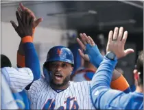  ?? MARK LENNIHAN - THE ASSOCIATED PRESS ?? New York Mets’ Robinson Cano is congratula­ted by teammates after scoring on a double by Todd Frazier against the San Diego Padres in the first inning of a baseball game, Thursday, July 25, 2019 in New York.