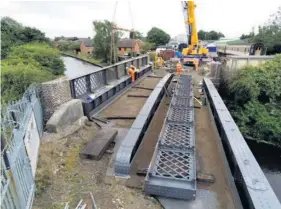  ??  ?? MISSING LINKS: Work taking place on the refurbishe­d canal bridge, in July