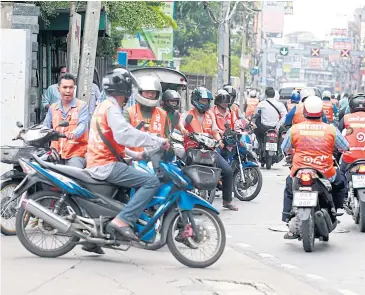  ?? THANARAK KHUNTON ?? Motorcycle taxis mass on a road in Bangkok. They are among the self-employed workers targeted as members by the National Savings Fund.