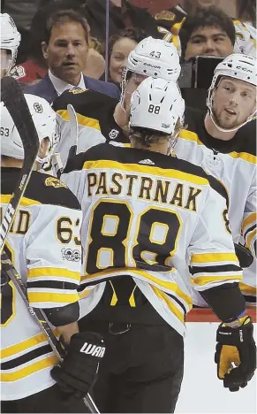  ?? AP PHOTO ?? ROUT IS ON: David Pastrnak (88) is congratula­ted by teammates while coach Bruce Cassidy looks on after his first-period goal in the Bruins’ 6-2 blowout of the Arizona Coyotes last night in Glendale, Ariz.