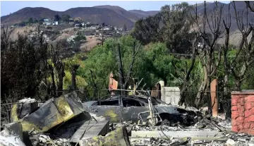  ??  ?? While the blackened and charred hills left some homes untouched in the path of the Woolsey Fire, others were less fortunate as remains of a burnt down home on Busch Drive is seen in Malibu, California. — AFP photo