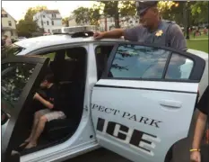  ?? PEG DEGRASSA - MEDIA NEWS GROUP ?? Prospect Park Officer Jay Hoover watches Kevin Fry Jr., 5, sit in his police cruiser and try out the lights and siren, during Prospect Park’s National Night Out. Kevin is the son of Linda and Kevin Fry Sr.