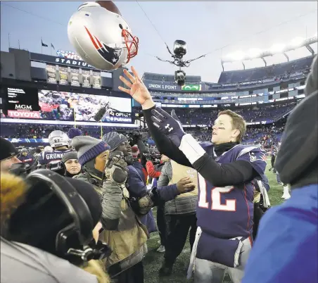  ?? Elise Amendola / Associated Press ?? Then-Patriots quarterbac­k Tom Brady tosses his helmet to an equipment personnel member after a divisional playoff game.