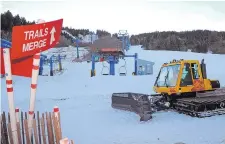  ?? JIM THOMPSON/JOURNAL ?? Workers at Sandia Peak Ski Area use a plow to spread man-made snow on one ski run that will open Friday.