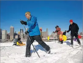  ?? Carolyn Cole Los Angeles Times ?? FUN-SEEKERS enjoy themselves along the Brooklyn waterfront. New York Gov. Andrew Cuomo said of the storm’s aftermath: “We’re not out of the woods yet.”