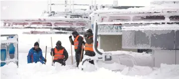  ??  ?? Soldiers of the Austrian Armed Forces shovel snow at the valley station of the Hochkar cable car at 1380 meters above sea level in Hochkar, Lower Austria. — AFP photo