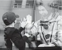  ?? Dmitri Lovetsky / Associated Press ?? NASA astronaut Nick Hague waves to his son from a bus prior to the failed launch of a Soyuz rocket on Oct. 11 in Kazakhstan. “I’m excited about it. I’m 100 percent ready to go,” Hague said of the next launch set for Feb. 28.