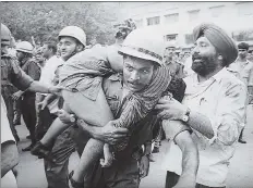  ?? PRAKASH SINGH/HT ARCHIVE ?? A police official rushes a victim to the hospital.