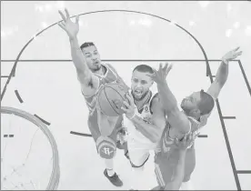  ??  ?? Stephen Curry, centro, de los Golden State Warriors, salta entre Gerald Green, izquierda, y Eric Gordon, de los Houston Rockets ■ Foto