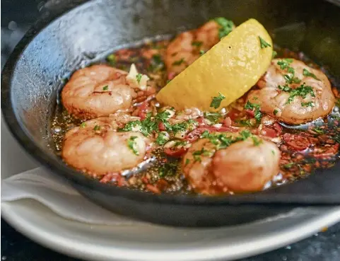  ?? Pictures by Jason Hedges. ?? The gambas pil-pil arrived theatrical­ly at the table, and the flavour didn’t disappoint, with juicy prawns and garlicky oil.