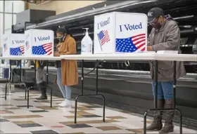  ?? Emily Matthews/ Post- Gazette ?? Lee Brown, right, of Wilkinsbur­g, fills out her ballot Sunday during the Turn Up the Vote event at the vacant Shop ’ n Save in the Hill District.