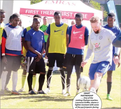  ??  ?? SMART PARTNERSHI­P . . . One of the visiting Chelsea coaches, Laurence Griffin, shares a lighter moment with some of the participan­ts during their drills yesterday at Belgravia Sports Club in Harare