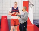  ?? EDDIE MOORE/JOURNAL ?? Sebastian Forsling, Lobo basketball freshman, and team strength coach Matt Flores talk during a recent practice. The 7-foot Swede is adjusting both to the U.S. and college basketball.