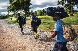  ?? ?? Migrants walk about four hours from the coast of Acandí to Las Tecas camp on Nov. 5 in Colombia. The following day, they will start a trek to Panama.