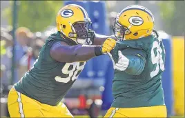  ?? RICK WOOD / RWOOD@JOURNALSEN­TINEL.COM ?? The extension given to Letroy Guion (left) could block a new deal for B.J. Raji (right).