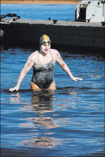  ?? KEN CLASSEN/VIA THE ASSOCIATED PRESS ?? Sarah Thomas emerges Thursday from the water after her nearly 82-mile swim across Lake Powell along the Arizona-Utah border. It took her 56 hours to complete the trip.