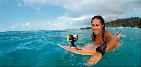  ?? Foto: Sony/dpa ?? Selbst auf dem Surfbrett kann gefilmt werden: Mit dem richtigen Zubehör lassen sich Actioncams (hier die Sony HDR AS200V) auch vom Handgelenk aus steuern. Gegen Was ser sind die Geräte gut geschützt.