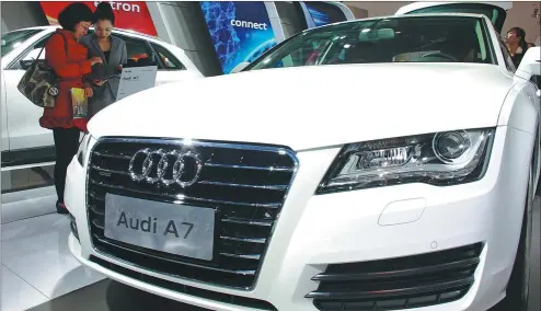  ?? PHOTOS PROVIDED TO CHINA DAILY ?? Visitors admire an Audi A7 produced by FAW-Volkswagen Group at an auto show in Haikou, Hainan province.