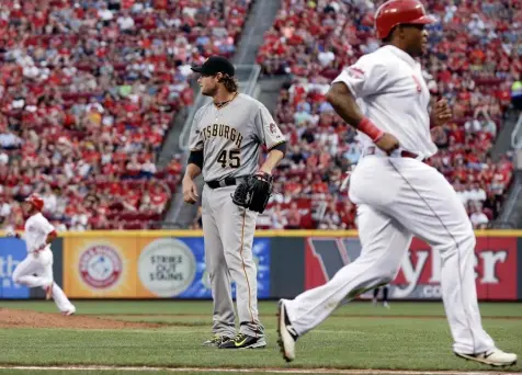  ?? John Minchillo/Associated Press ?? Gerrit Cole again found the Reds to be trouble. He allowed three runs on seven hits in five innings Saturday night. Here, Marlon Byrd scores on a double by Eugenio Suarez to give the Reds a 2-1 lead in the fourth.