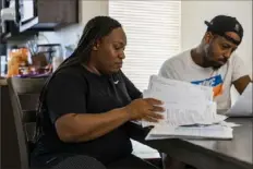  ?? (Joe Buglewicz/The New York Times ?? Tawana Smith and her husband, Akeem, look over past and current eviction paperwork in their Las Vegas home. The Smith family has faced eviction several times since the start of the pandemic.