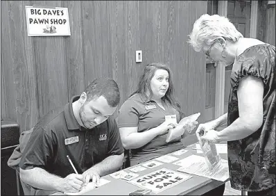  ?? Special to the Democrat-Gazette ?? A woman makes a transactio­n at the pawnshop booth during last week’s poverty simulation at the University of Central Arkansas in Conway. The event was intended to help people better understand poverty.