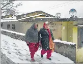  ?? AP ?? People walk on a snow-covered road in Joshimath on Friday.