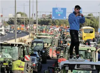  ?? /Reuters ?? Tractor
factor: A man stands on a tractor, as farmers block the A2 highway during a protest against price pressures, taxes and green regulation in Barcelona, Spain, February 7.