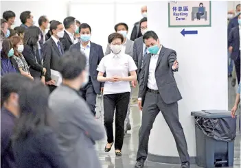  ?? — AFP photo ?? Carrie Lam (centre) arrives to receive China’s Sinovac Covid-19 coronaviru­s vaccine at the Community Vaccinatio­n Centre in Hong Kong.